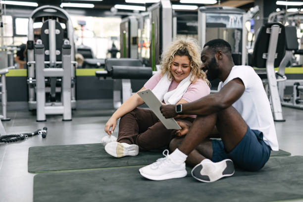 istock Two individuals sitting on mats with clipboard in gym. 2168645891