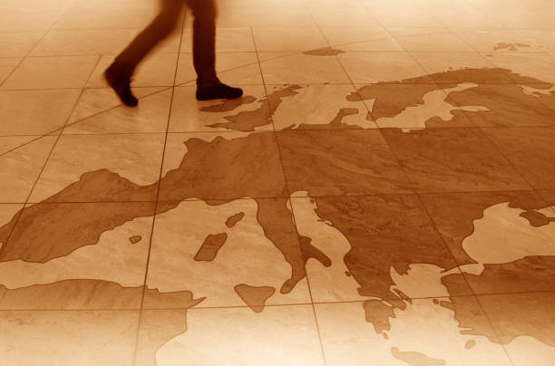 Europe map on floor, young man crossing it.