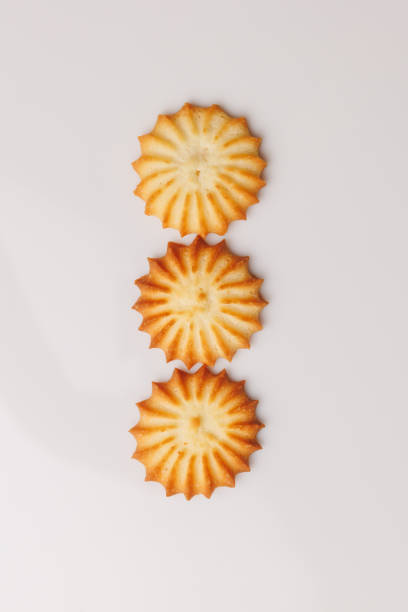 A baking tray filled with various shaped panellets, including round and quince-filled versions, prepared for the oven during the Castañada celebration in Catalonia. The image showcases the final stage before baking, emphasizing the traditional and homemade aspects of this festive dessert.