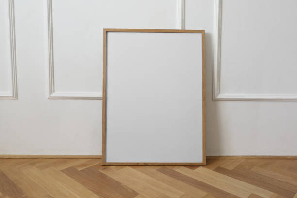istock Vertical thin picture frame mockup. Empty frame poster mock-up template on oak wooden parquet floor. White wall background, elegant stucco decor. Minimal Scandinavian interior, living room. Front view. 2168663848
