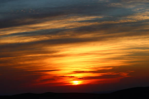 The sun setting behind the clouds. Orange sky. Amazing sunset