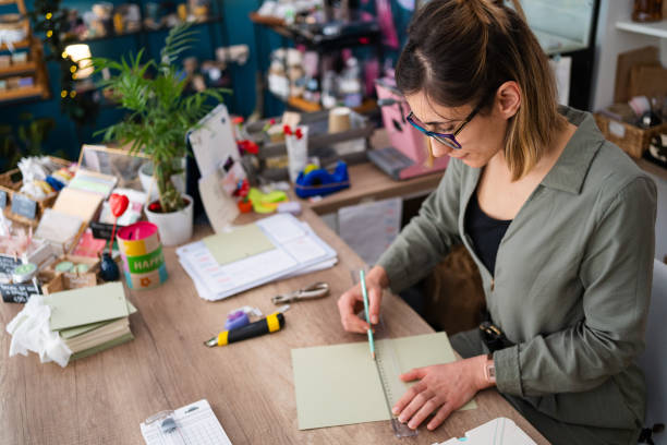 istock Small business owner making wedding invitation cards while working in her flower shop 2168671202