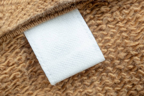 istock White blank laundry care clothes label on brown shirt fabric background 2168676269