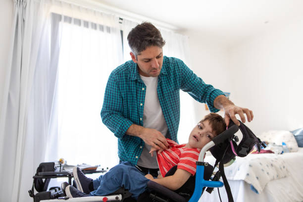 istock Beautiful boy with cerebral palsy  being changed by his father 2168684640