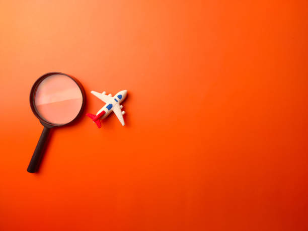 istock Top view magnifying glass and toy air plane on a orange background 2168685066