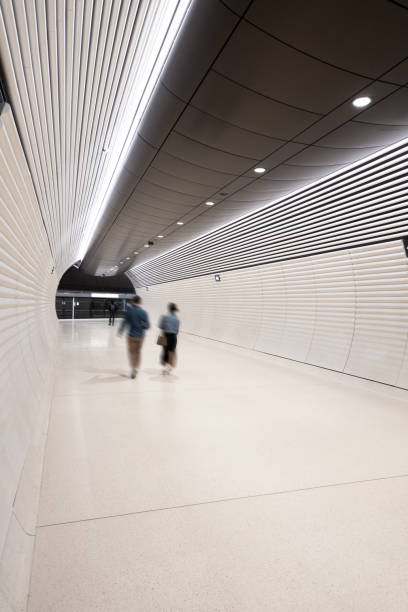 istock Motion blurred commuters make their way through the vast futuristic styled tunnel system of the new Gadigal Metro Station 2168688174