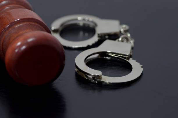 a gavel and handcuffs, symbolizing the justice system's power to both uphold and enforce the law. The gavel represents the authority to make decisions, while the handcuffs signify the potential for punishment or restraint.