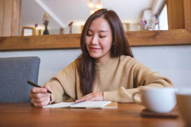 istock Portrait image of a young woman writing on a notebook on the table 2168702315
