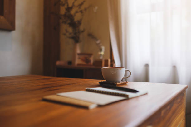 istock Notebooks and a coffee cup on wooden table 2168702347
