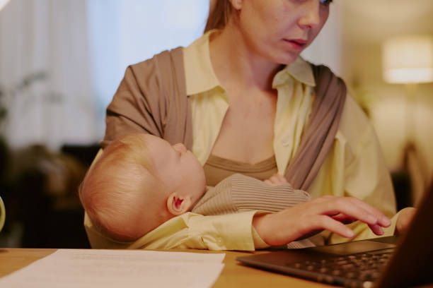istock Multitasking Mother Working and Holding Baby at Home 2168709837