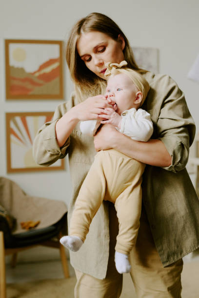 istock Holding Blond Toddler with Gentle Expression in Cozy Room 2168710026