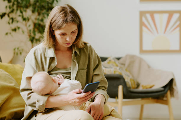 istock Caring for Baby While Checking Phone in Living Room 2168710767