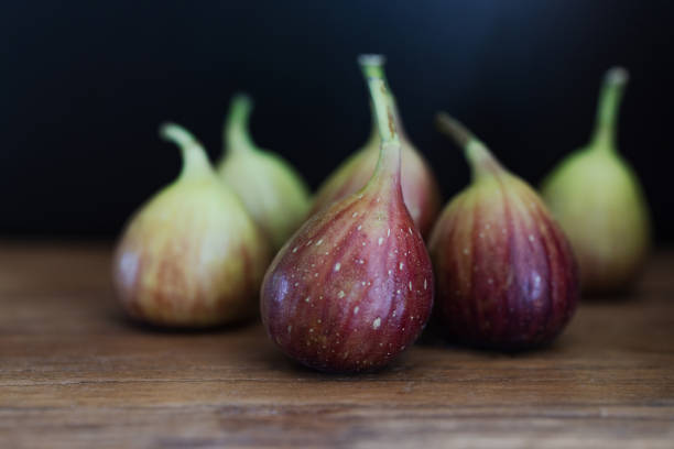Fresh figs. A few fig halves on an old tree background, copy space