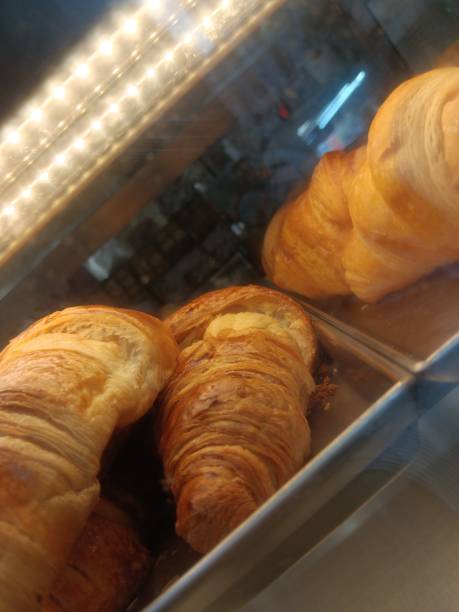 istock Croissants with buttery scent dancing over window display 2168714828