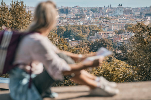 istock Young female tourist reading a map while exploring big city 2168717138