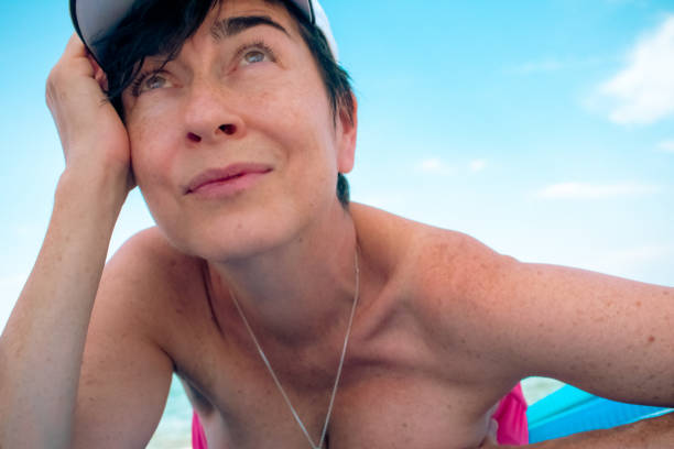Woman lying on a deckchair, sunbathing on the beach of the Adriatic coast