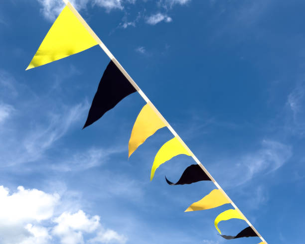 Black and yellow flags against a blue sky. Holiday.