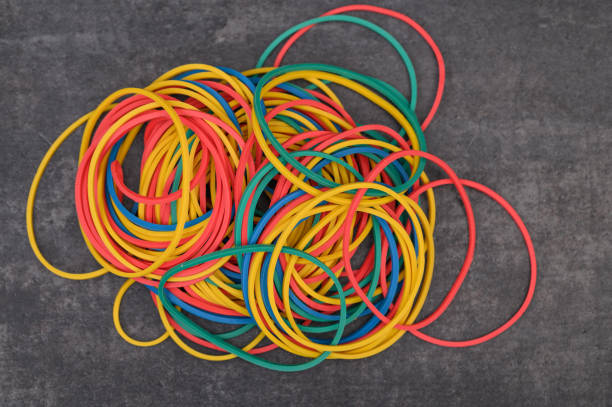 Colorful thin rubber bands insulated lie on the table, shot from above