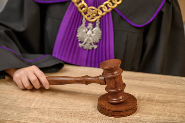 A judge issues a verdict in court, a judge's attire, a robe, a chain and an eagle,