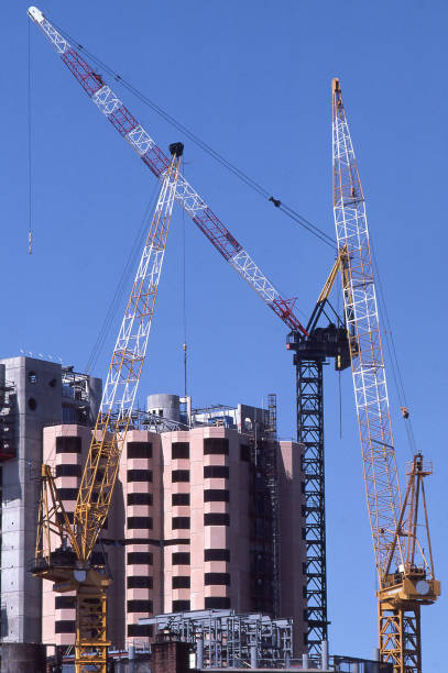 Exterior view of a large construction site with three cranes on the site