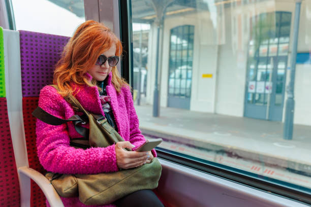 istock Woman in train using smart phone to text with chatbot 2168737608