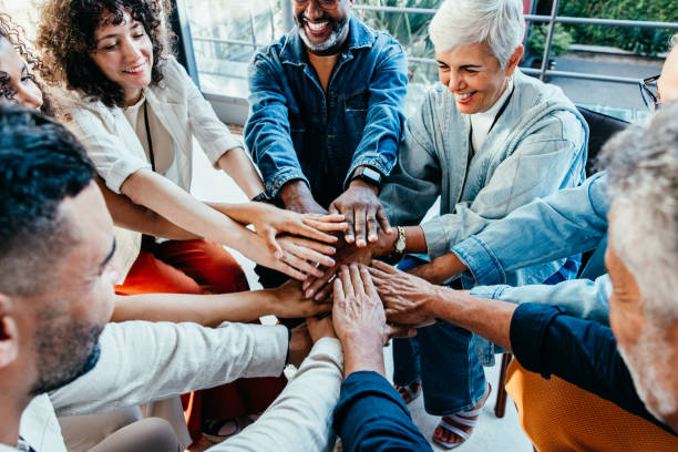 istock Co-workers gathering together, hands in unity, smiling and bonding in a team-building activity. 2168739118