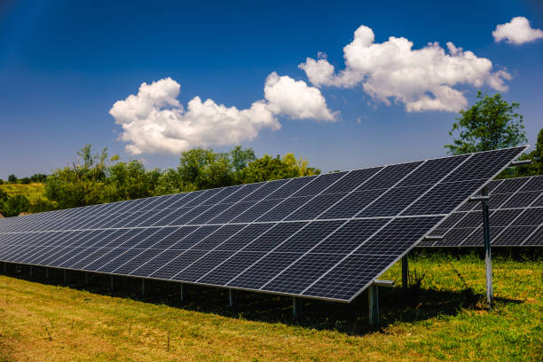 istock Tilted solar panels in agricultural field under the cloudy blue sky 2168739180