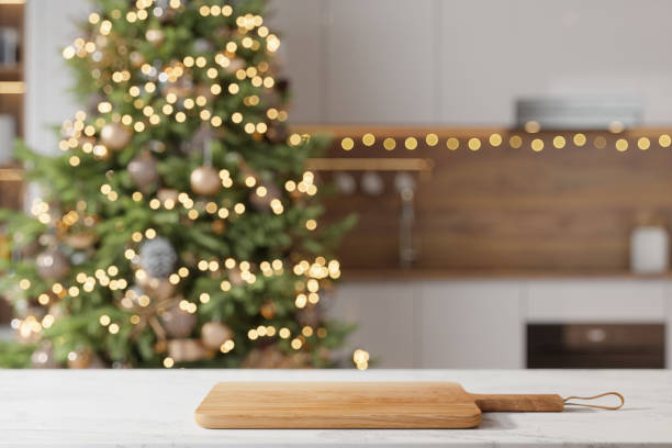 istock Wooden Cutting Board On Empty Marble Countertop With Blurred Kitchen And Christmas Tree Background 2168741767