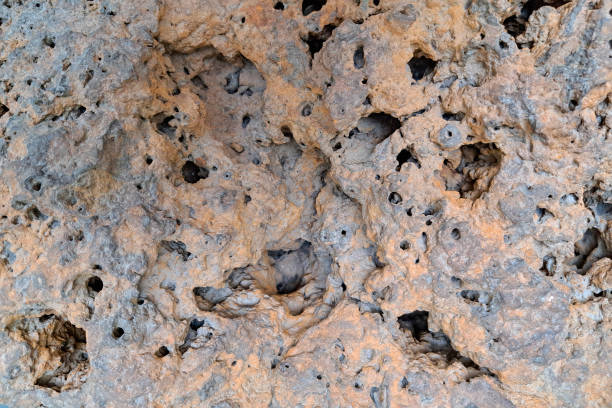 istock Porous, weathered brown rock with numerous small cavities and irregular surface texture. 2168742089