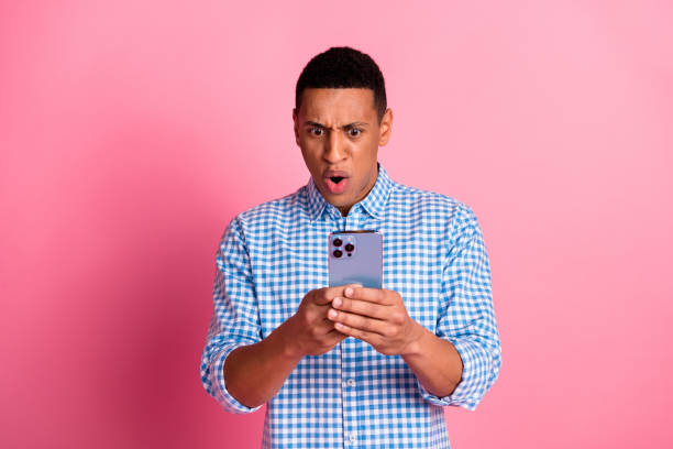 istock Photo of impressed positive guy dressed checkered shirt communicating modern device emtpy space isolated pink color background 2168743630