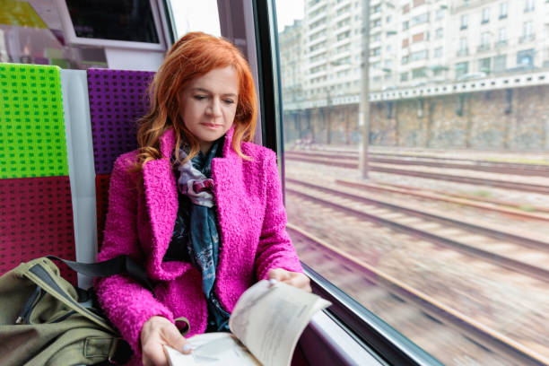 istock Beautiful middle-aged woman reading in train 2168744419