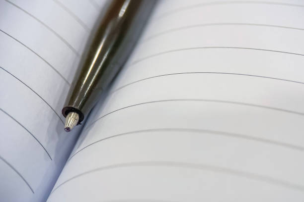 istock Captured by a sleek pen resting in an open book. 2168744464