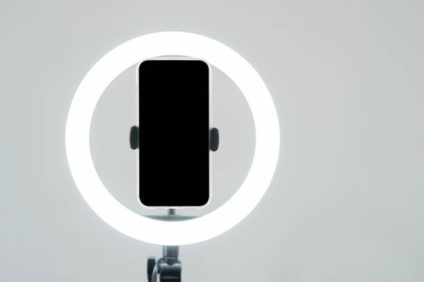istock Tripod with ring light and smartphone with black screen over white color blackground. 2168745916