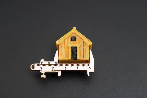 Caliper alongside a miniature wooden house, highlighting precision measurement in construction and design. Ideal for architecture, real estate, and DIY projects.