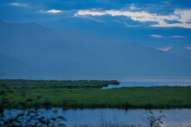 istock Tranquil lake with misty mountains at dawn 2168756910