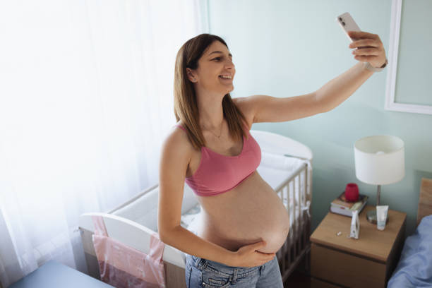 istock Happy pregnant woman taking a selfie 2168757516