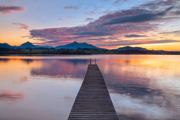 istock Long Wooden Pier into Lake Hopfensee at Sunset 2168761128