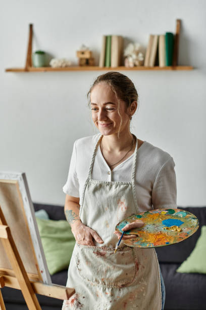 istock A creative woman with vitiligo expresses joy while painting at home in a cozy environment 2168763232