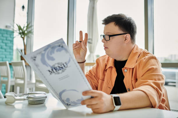 istock A young man with Down syndrome exploring the cafe menu during a casual outing 2168764892