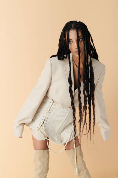 istock Stylish young woman with braided hair poses dramatically in a chic studio setting 2168773193