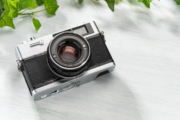 istock Old film camera isolated on wooden table 2168775135