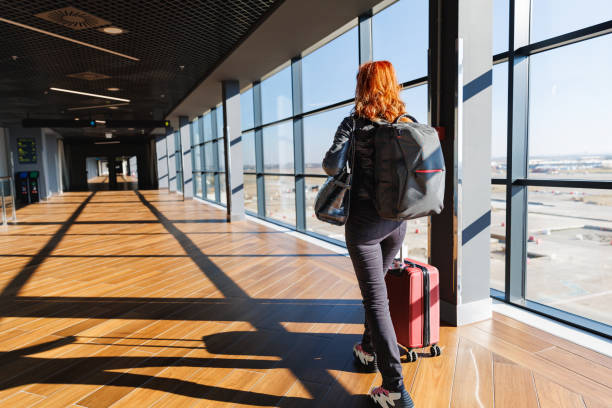 istock Woman traveling by plane, walking through the gate, pulling suitcase 2168775796