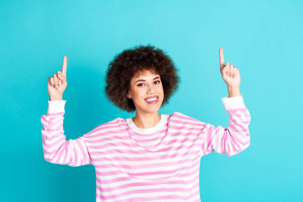 istock Photo of cheerful pretty lady dressed pink pullover pointing two fingers up empty space isolated teal color background 2168776501
