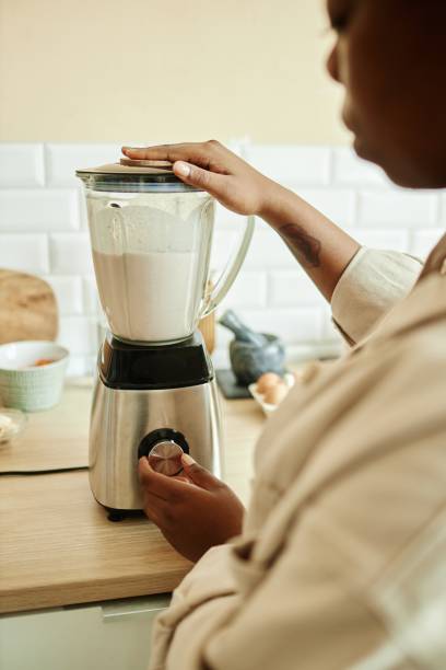 istock Black Woman Using Blender Mixing Milk with Fruits at Kitchen 2168777428