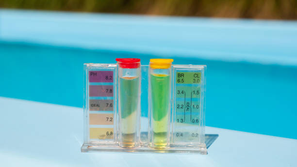 istock A pool water testing kit shows pH and chlorine levels with colored indicators, placed on the poolside against a clear blue water background. 2168778580