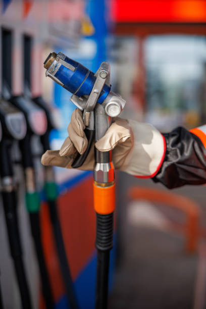 istock Hand in protective glove holding LPG (liquefied petroleum gas) nozzle at fuel pump 2168779620