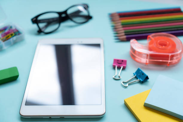 School and office supplies with digital tablet on blue background