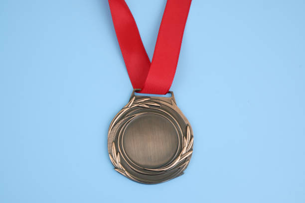 Bronze medal with red ribbon on blue background.