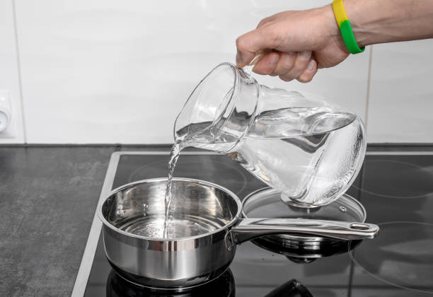 istock Pour water into a pot on the stove burner 2168795147