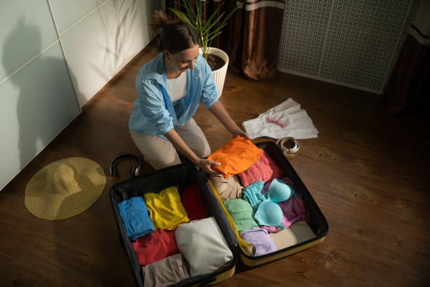 istock Woman organizing clothes arranging suitcase 2168797645